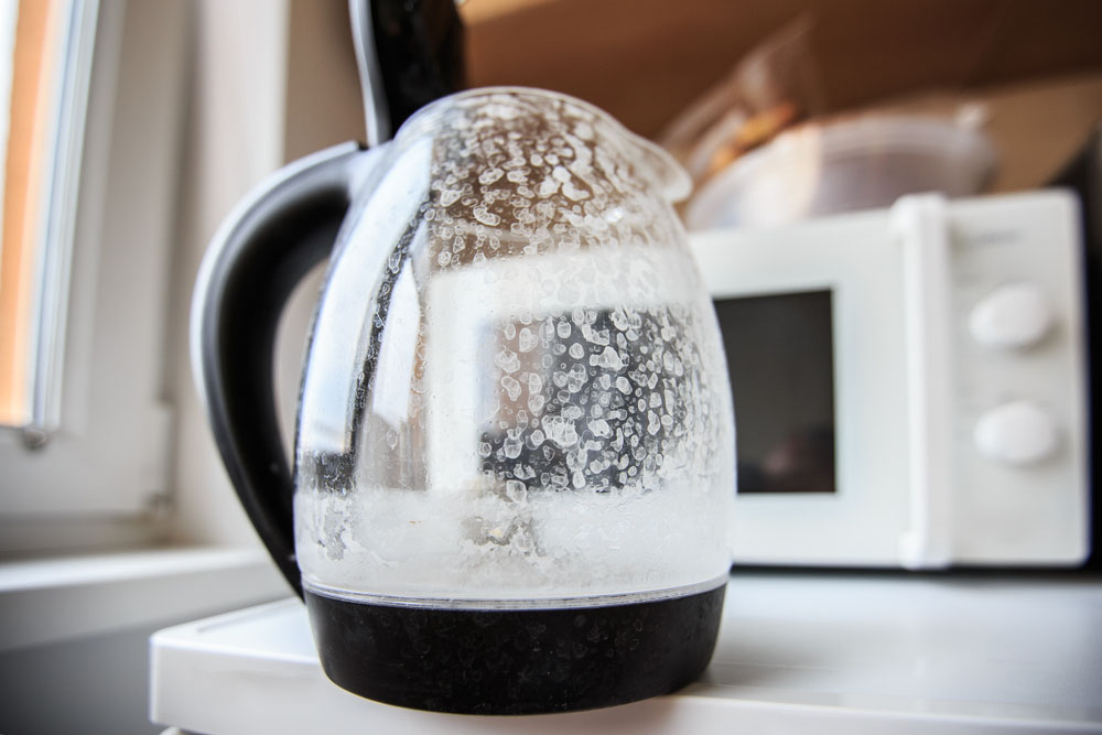 Electric kettle with condensation and mineral deposits, illustrating hard water effects in a kitchen setting.